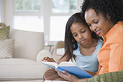 Photo d'une maman lisant un livre à sa fille