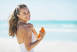 Photo d'une femme se mettant de la crème solaire