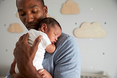 Personne portant un enfant en bas âge dans ses bras