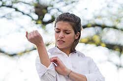 Femme qui gratte un bouton de moustique