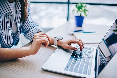 Une jeune femme travaille sur un ordinateur portable